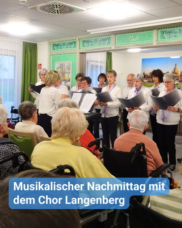 Ein gemischter Chor singt vor einer Gruppe Seniorinnen und Senioren. Bildbeschriftung: Musikalischer Nachmittag mit dem Chor Langenberg