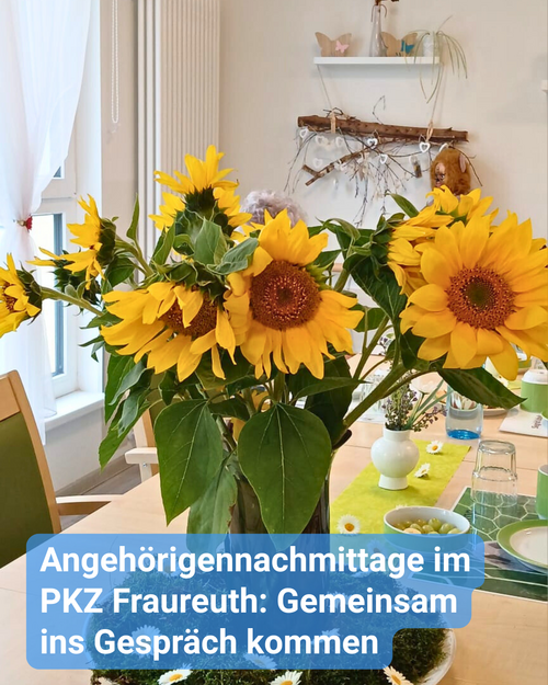 Ein heller, freundlicher Raum mit einer gedeckten Kaffeetafel, wo inmitten ein leuchtend gelber Sonnenblumenstrauß steht. Bildbeschriftung: „Angehörigennachmittage im PKZ Fraureuth: Gemeinsam ins Gespräch kommen“