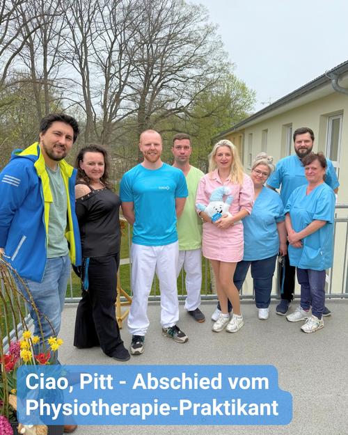 Auf Augenhöhe betrachtet, steht eine Gruppe von Menschen, überwiegend Frauen, im Freien auf einer Terrasse oder einem gepflasterten Bereich.  Sie wirken wie Kollegen oder ein Arbeitsteam, und die Atmosphäre des Geschehens ist von Abschied oder Feierlichkeit geprägt. Ein Mann in der Mitte trägt ein leuchtend blaues Hemd, was darauf hindeutet, dass er im Mittelpunkt der Aufmerksamkeit steht, möglicherweise als scheidender Praktikant oder Mitarbeiter, wie der Textüberlagerung zu entnehmen ist.  Mehrere Frauen in unterschiedlichen Farbtönen von Oberteilen und Hosen sind zu sehen, während im Hintergrund einige Männer stehen. Eine der Frauen in der ersten Reihe hält ein kleines Stofftier in den Händen. Die im Hintergrund sichtbaren Gebäude und Bäume deuten auf eine Einrichtung im Gesundheitswesen oder ein Krankenhaus hin.  Die Textüberlagerung am unteren Rand, in Deutsch verfasst, lautet: "Ciao, Pitt - Abschied vom Physiotherapie-Praktikant," was übersetzt "Ciao, Pitt - Farewell from the physiotherapy intern" bedeutet. Dies bestätigt, dass es sich um eine Abschiedsfeier für den Physiotherapie-Praktikanten Pitt handelt.