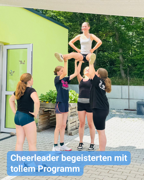 Vier junge Cheerleader heben eine Fünfte in einer Hebefigur im Freien. Text: 'Cheerleader begeisterten mit tollem Programm'.
