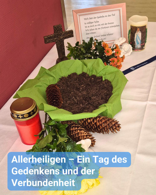 Symbolischer Gedenktisch zu Allerheiligen im Seniorenpflegeheim Haus Steinwaldblick in Wiesau – mit Erde, Kreuz, Blumen, Grablicht und Gedenkkerze als Zeichen des Glaubens, der Erinnerung und Verbundenheit.