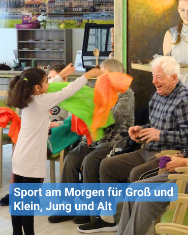 Ein Mädchen im Kindergartenalter, mit zwei Zöpfen, bewegt bunte Tücher innerhalb eines Kreises von Seniorinnen und Senioren. Diese sind begeistert und lachen herzlich. Bildbeschriftung: Sport am Morgen für Groß und Klein, Jung und Alt