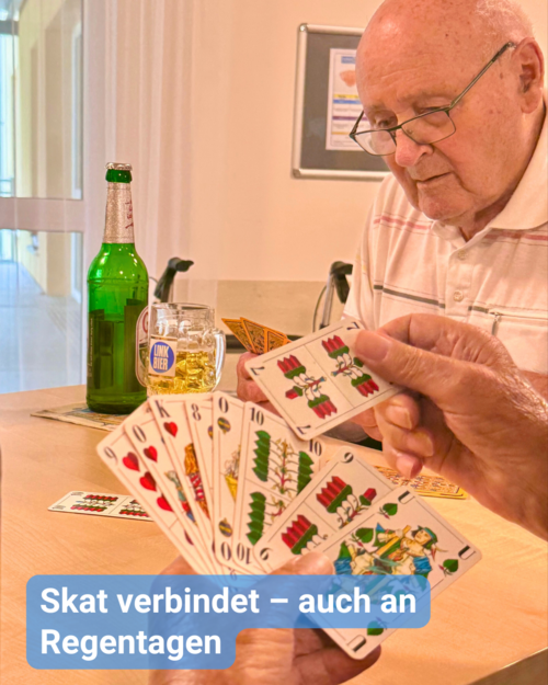 Senioren sitzen gemeinsam am Tisch und spielen Skat. Dabei genießen Sie ein Bier. Bildbeschriftung: Skat verbindet – auch an Regentagen