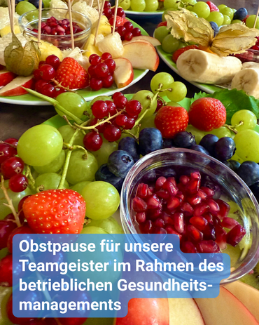Obstteller mit Blaubeeren, Weintrauben, Erdbeeren, Granatapfelkernen und vielen mehr. Bildbeschriftung: „Obstpause für unsere Teamgeister im Rahmen des betrieblichen Gesundheitsmanagements“