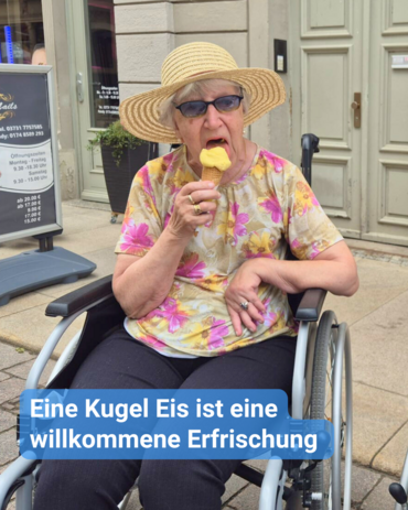 Ältere Frau im Rollstuhl isst genüsslich ein Eis auf der Straße. Text: 'Eine Kugel Eis ist eine willkommene Erfrischung'.