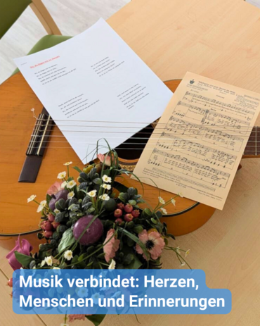 Eine Gitarre liegt auf einem Tisch, zusammen mit Notenblättern und Songtexten. Bildunterschrift: Musik verbindet: Herzen, Menschen und Erinnerungen