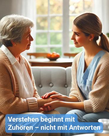 Eine junge Pflegekraft sitzt auf einem Sofa einer Seniorenresidenz einer älteren Frau mit grauen Haaren gegenüber. Beide tragen beige Strickjacken. Die Pflegekraft hält behutsam die Hände der Seniorin, beide blicken sich auf Augenhöhe freundlich in die Augen. Im Hintergrund ist ein heller, gemütlicher Raum mit großen Fenstern zu sehen. Auf dem Bild steht der Text: „Verstehen beginnt mit Zuhören – nicht mit Antworten“.