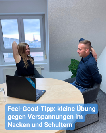 Zwei Kollegen machen im Büro Dehnübungen für die Schulter. Bildbeschriftung: Feel-Good-Tipp: kleine Übung gegen Verspannungen im Nacken und Schultern