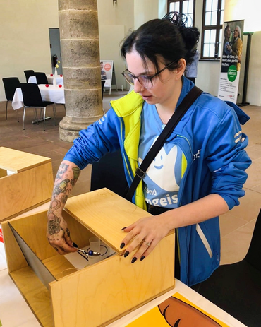 Frau probiert aus, wie man ohne Sicht isst.