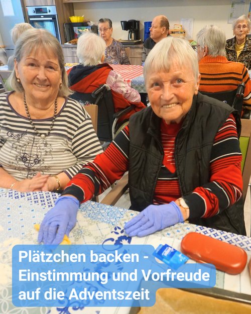 In einer Gemeinschaftsküche sind Seniorinnen und Senioren gemeinsam am Backen. Im Vordergrund sind zwei Seniorinnen, die in die Kamera lächeln und Teig zubereiten. Bildbeschriftung: „Plätzchen backen – Einstimmung und Vorfreude auf die Adventszeit“