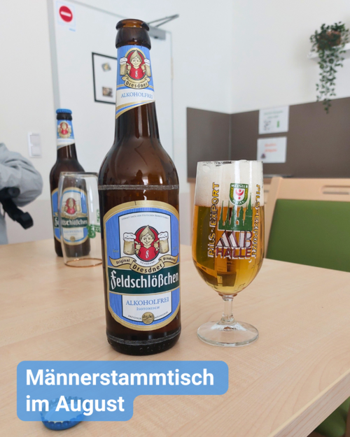 Gemütliches Beisammensein bei einem alkoholfreien Bier – ein Tisch mit Bierflasche und einem Bierglas ist zu sehen. Bildbeschriftung: Männerstammtisch im August
