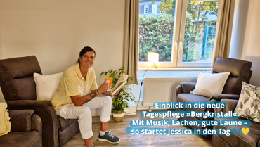 Eine weibliche Betreuungskraft im gelben Polo-Shirt und in weißer Hose sitzt in einem gemütlichen braunen Sessel, hält eine Tasse in der rechten und ein Buch in der linken Hand. Sie lächelt in die Kamera. Bildbeschriftung: „Einblick in die neue Tagespflege ›Bergkristall‹: Mit Musik, Lachen, gute Laune – so startet Jessica in den Tag"