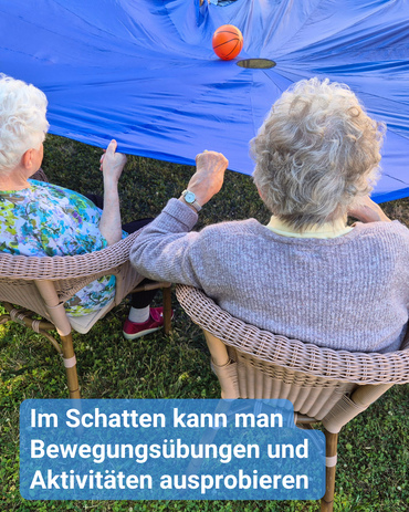 Zwei ältere Frauen sitzen im Schatten unter einem blauen Tuch, das einen Ball hält. Text: 'Im Schatten kann man Bewegungsübungen und Aktivitäten ausprobieren'.