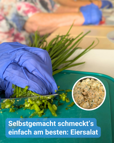 Eine behandschuhte Hand schneidet Schnittlauch. Eine Schüssel von Eiersalat ist ebenfalls zu sehen. Bildbeschriftung: Selbstgemacht schmeckt’s einfach am besten: Eiersalat