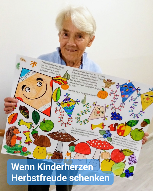 Seniorin hält erfreut ein Herbstbild in die Kamera. Bildbeschriftung: Wenn Kinderherzen Herbstfreude schenken