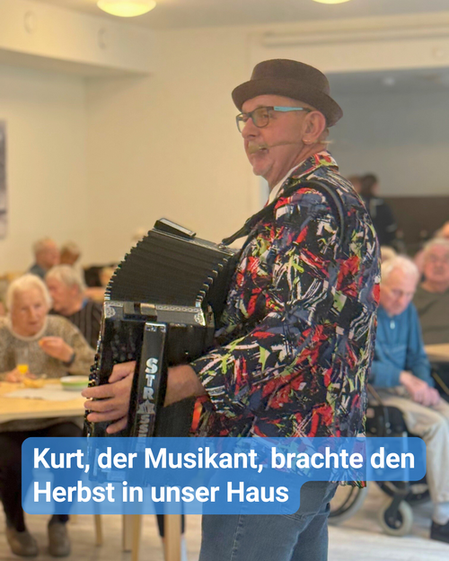 Ein Musiker mit Hut und Schifferklavier. Im Hintergrund sieht man Seniorinnen und Senioren im Publikum. Bildbeschriftung: Kurt, der Musikant, brachte den Herbst in unser Haus.