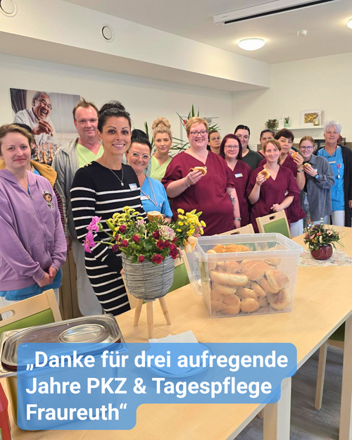 Ein Team von Pfleger:innen und Betreuer:innen steht lächelnd um einen gedeckten Tisch, sie feiern ein Jubiläum. Bildbeschriftung: „Danke für drei aufregende Jahre PKZ & Tagespflege Fraureuth“